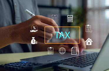 Businessman analyzing tax and finance data using a laptop with digital icons, symbolizing online taxation, accounting, financial planning, and digital economy management concept.