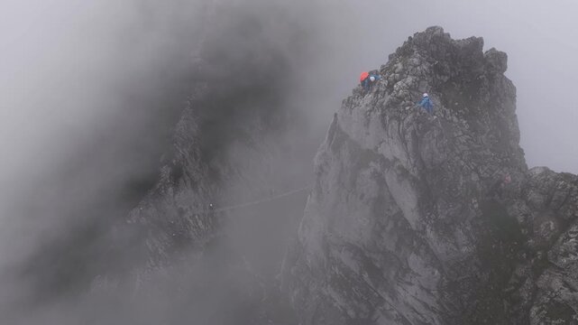 Aerial view of climbers on a foggy mountain peak in the austrian alps, Dachstein, Austria