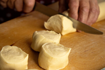 Close-up of Hands Using a Knife to Cut Raw Dough for Dumplings