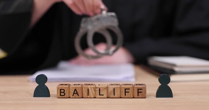 Bailiff presenting handcuffs during courtroom proceedings, showcasing legal authority and the judicial process in action