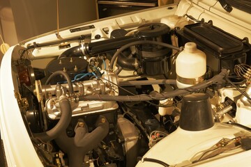 The polished engine of a Wartburg 353 is photographed in detail from above inside the engine bay at Retro Museum Varna, showing its shiny and well-restored components