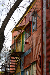 Vertical image of a colorful two-story house with tiled walls in La Boca, Buenos Aires