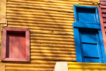Wooden windows amidst a tiled wall in a building in the La Boca neighborhood of Buenos Aires