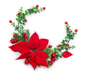 Christmas decoration with red poinsettia flowers, red berries and fir branches on a white background with copy space. Top view, flat lay