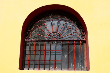 An arched window in a yellow wall