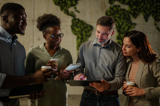 Diverse business team collaborating using digital tablet during break
