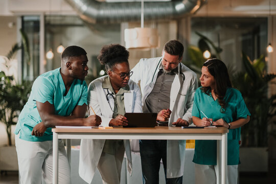 Diverse medical team collaborating on digital tablet