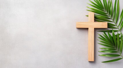 Wooden cross and palm leaf resting on a grey surface, capturing a moment of reflection and peace in a serene alleyway setting