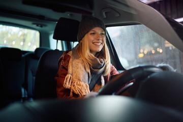 Young happy woman driving her car during winter. © Drazen