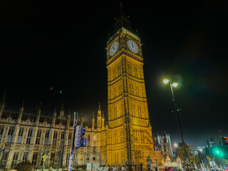 Fototapeta premium Beautiful night an Sunset view of Big Ben and the Houses of Parliament in London, illuminated over the River Thames with city lights reflecting on the water. UK
