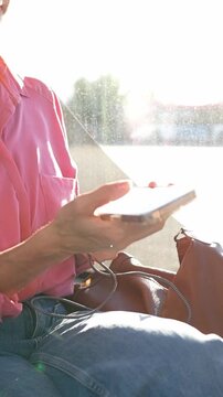 Woman's hand plugging a usb cable into a charging port on a public city bus. Modern transport convenience for charging electronic devices