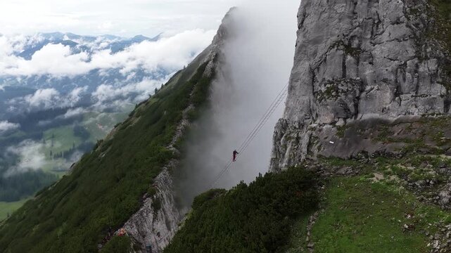 Adventurous climber crossing a suspension bridge in the alps, Dachstein, Austria