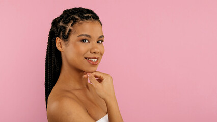 Beautiful young black woman in towel touching chin and smiling at camera, attractive african...