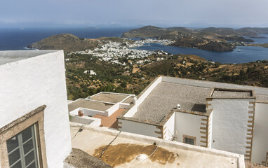 the Monastery of Saint John the Theologian with sea view, stone walls, cloudy sky, landscape on the island of Patmos, Greece.