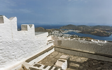 the Monastery of Saint John the Theologian with sea view, stone walls, cloudy sky, landscape on the island of Patmos, Greece.