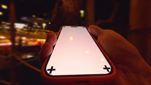 Hand Holding Smartphone with Corner Tracking Marks at Night as Blurred Person Rapidly Moves in Background from First-Person Low Angle Time-Lapse Effect Disorientation and Technology Concept