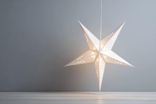 Christmas star decoration hanging against grey wall