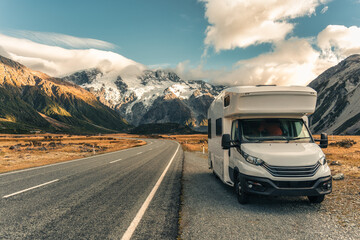 Motorhome parked on roadside with Mount Cook over road in autumn at New Zealand