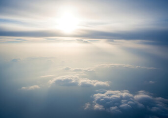 Obraz premium Sunbeams breaking through soft white clouds at high altitude sunlight