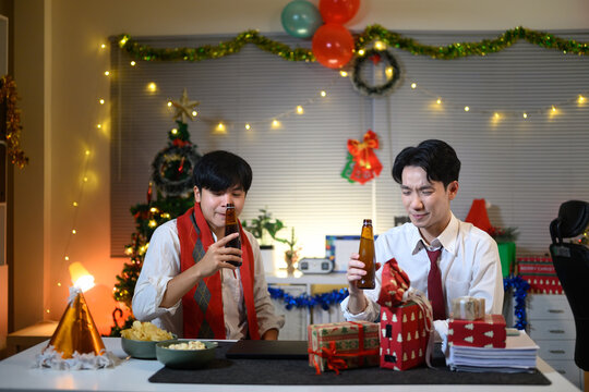 Business people are celebrating holiday in modern office drinking beer and having fun in co working.