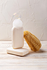 Health and hygiene. Minimalist soap display featuring two bars of soap, one with bubble and natural sponge, arranged on wooden surface, creating serene atmosphere for skincare and relaxation