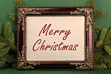 Merry Christmas. Elegant frame showcases festive message, surrounded by lush pine branches against rich green background, creating warm and inviting holiday atmosphere for seasonal celebrations
