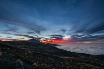 Vibrant sunset sky over Mount Teide in Tenerife, Canary Islands. Dramatic colorful clouds illuminate the volcanic landscape during the golden hour. A stunning scene capturing the beauty of Teide