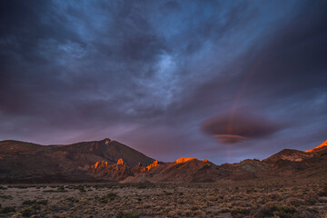 Vibrant sunset sky over Mount Teide in Tenerife, Canary Islands. Dramatic colorful clouds illuminate the volcanic landscape during the golden hour. A stunning scene capturing the beauty of Teide
