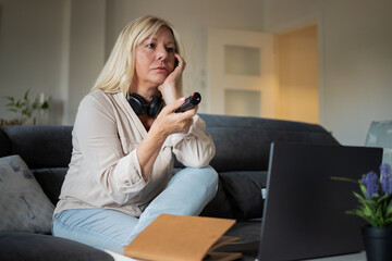Frustrated woman experiencing boredom watching television at home