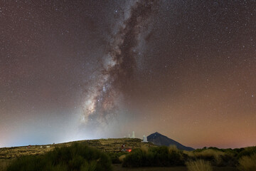 Stunning night sky over Mount Teide in Tenerife, Canary Islands. The Milky Way arches across the sky above the volcanic landscape of Teide National Park. A breathtaking astrophotography scene perfect 