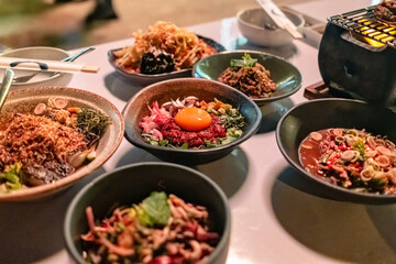 Isaan fusion food cuisine with various rare meat with herb, spicy salad on the table in restaurant