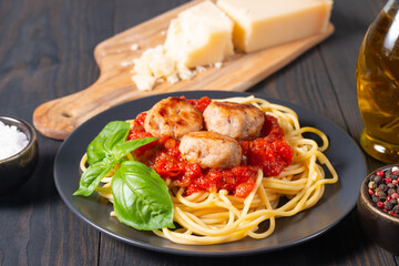 Delicious spaghetti with tasty meatballs in tomato sauce, and basil on background. Restaurant menu.