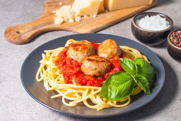 Delicious spaghetti with tasty meatballs in tomato sauce, and basil on background. Restaurant menu.