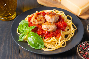 Delicious spaghetti with tasty meatballs in tomato sauce, and basil on background. Restaurant menu.