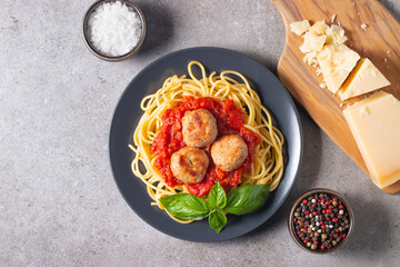 Delicious spaghetti with tasty meatballs in tomato sauce, and basil on background. Restaurant menu.