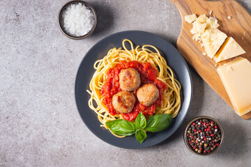 Delicious spaghetti with tasty meatballs in tomato sauce, and basil on background. Restaurant menu.