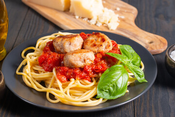 Delicious spaghetti with tasty meatballs in tomato sauce, and basil on background. Restaurant menu.