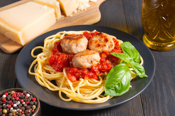 Delicious spaghetti with tasty meatballs in tomato sauce, and basil on background. Restaurant menu.