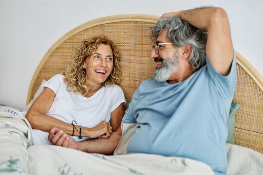 Portrait of a happy senior couple embracing each other on bed, elderly couple at home