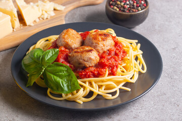 Delicious spaghetti with tasty meatballs in tomato sauce, and basil on background. Restaurant menu.