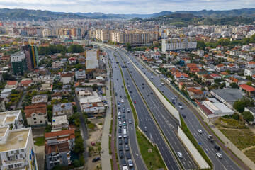 Obraz premium Aerial view of Tirana, Albania, showing the west side of the outer ring road with moving traffic and nearby residential areas.