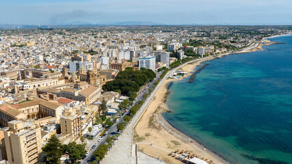 Fototapeta premium Aerial view of the seafront of Mazara del Vallo, a town in the province of Trapani, Sicily, Italy. The historic center overlooks the Mediterranean Sea. The sea's colors range from blue to turquoise.