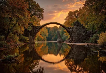 Tableau sur plexiglas Le Rakotzbrücke The Rakotzbrücke bridge in Germany, a famous arched bridge reflecting perfectly in the water during autumn.  © mirna