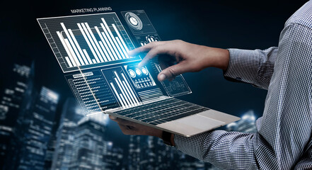 A person interacts with a digital screen over a laptop, showcasing marketing planning and analytics in a modern urban landscape, highlighting technology role. Impute