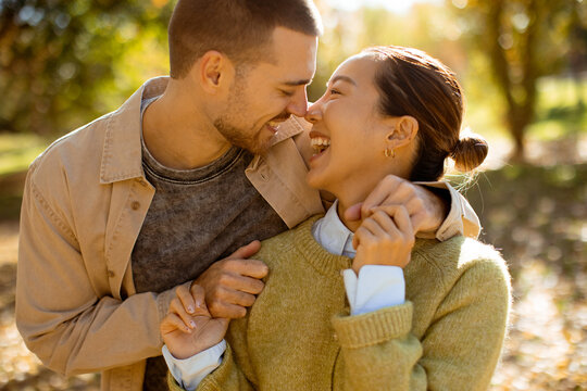 Joyful moments in the autumn sun between a couple in a serene park setting