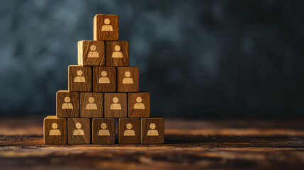 Wooden blocks stacked in a pyramid shape with person icons symbolizing team structure, hierarchy, and human resources.