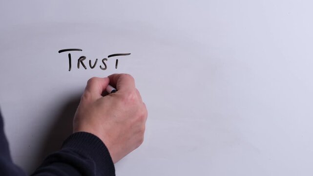 A person is writing Trust in Christ in black marker pen on a whiteboard, perfect for Christian, religious themes, Church communications or faith presentations