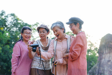 Senior Asian women smiling laughing watching photos cheerful casual clothing outdoor nature vacation travel freedom lifestyle relaxation friendship bonding journey happiness leisure adventure