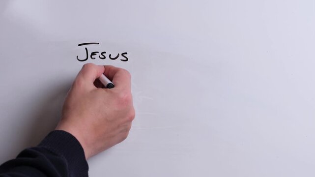 A person is writing Jesus is Coming in black marker pen on a whiteboard, perfect for Christian, religious themes, Church communications or faith presentations