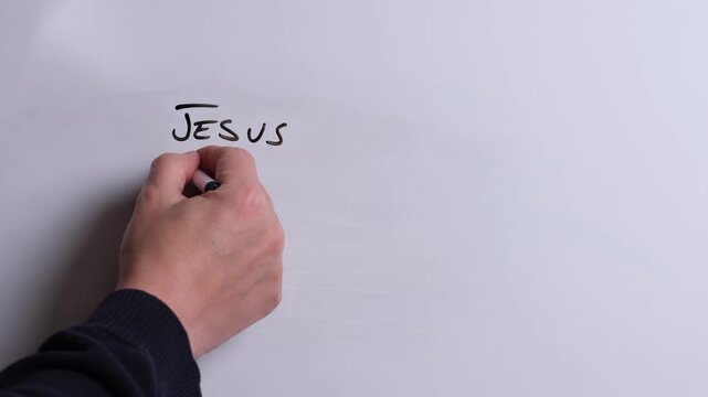 A person is writing Jesus Forgives Sinners in black marker pen on a whiteboard, perfect for Christian, religious themes, Church communications or faith presentations